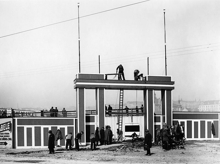 Dokončovací práce na vstupní bráně na rohu dnešní ulice Sportovní a Vršovické, tehdejší třídy Krále Jiřího.