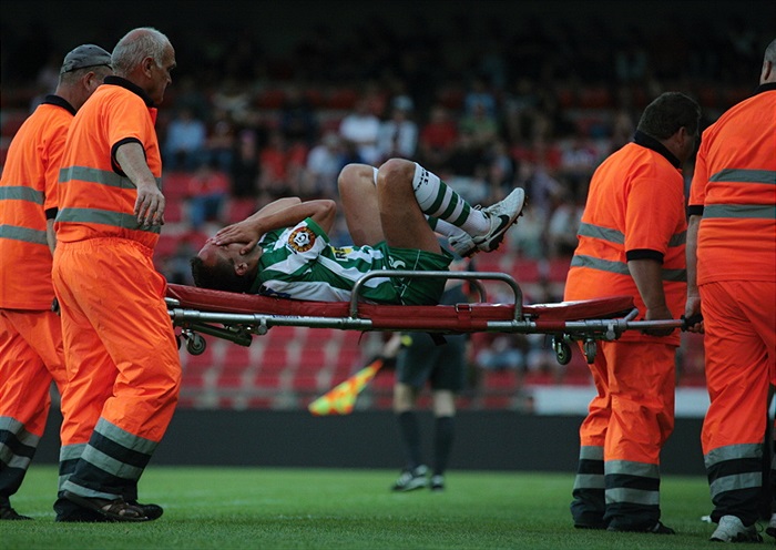 Dian opouští hřistě na nosítkách.